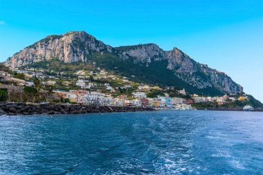 İtalya 'nın Capri adasında, Solaro ve Anacapri Dağı ile birlikte Marina Grande limanının dalgalı sularında bir manzara.