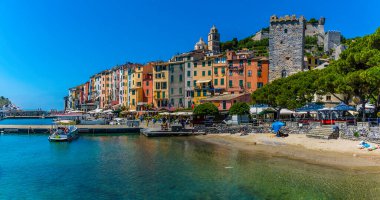 Porto Venere, İtalya 'da kumsal. Yazın rıhtımdaki renkli evlerin arkasında.