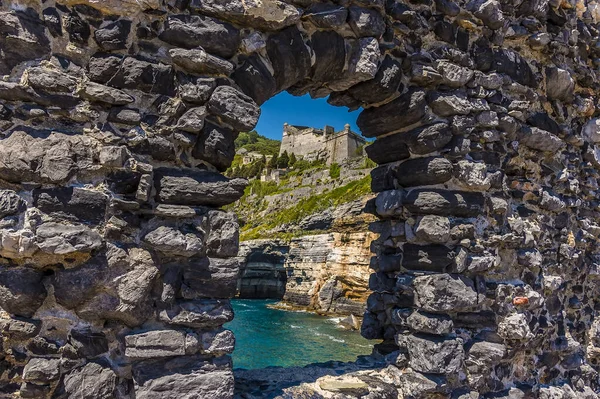 A view through a stone arch in Porto Venere, Italy along the Cinque Terre coastline in the summertime