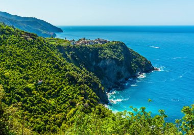 Yaz mevsiminde İtalya 'nın Corniglia kentindeki kayalıkların tepesine doğru uzanan sahil yolu boyunca bir manzara.
