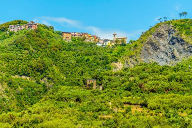 Yaz mevsiminde İtalya 'nın Corniglia köyünün üzerindeki kayalıkların manzarası