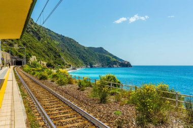 Yaz mevsiminde İtalya 'nın Corniglia kentindeki istasyon platformu ve kıyı şeridi boyunca bir manzara