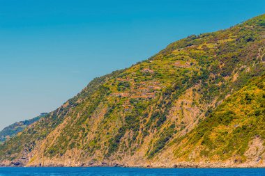 Yaz mevsiminde İtalya 'nın Porto Venere kenti yakınlarındaki Cinque Terre kıyısındaki uçurumlara tünemiş köylerin manzarası