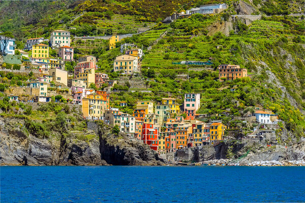 A view from the sea towards the harbour and village of Riomaggiore, Italy in the summertime