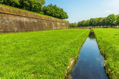 Lucca İtalya 'nın yaz aylarındaki surlarına paralel bir su kanalı manzarası.