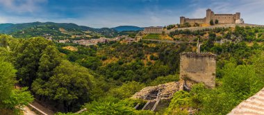 İtalya 'nın Spoleto şehrinde yaz mevsiminde vadi boyunca yıkık dökük bir kule, kaleyle çelişiyor.