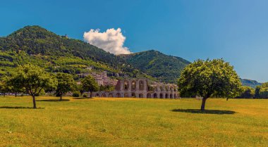 Ağaçlar, İtalya 'nın Gubbio kentinin önündeki Roma amfitiyatrosunun yaz manzarasını çerçevelediler.