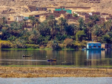 Kontrastlar, yaz aylarında Mısır 'ın Aswan kenti yakınlarında geleneksel kayık ve dizel pompalama istasyonlarıyla Nil Nehri' ne bakıyor.