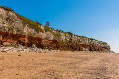 Eski Hunstanton, Norfolk, İngiltere 'nin beyaz, kırmızı ve turuncu katmanlı tebeşir kayalıkları boyunca batıya doğru bir manzara.