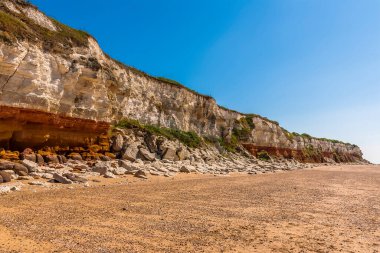 Batıya doğru Eski Hunstanton, Norfolk, İngiltere 'nin beyaz, kırmızı ve turuncu katmanlı tebeşir kayalıkları boyunca bir manzara.