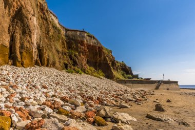 Beyaz, kırmızı ve turuncu kayalıklardan Norfolk, İngiltere 'deki Old Hunstanton deniz duvarına uzanan büyük kayalıklardan bir manzara.