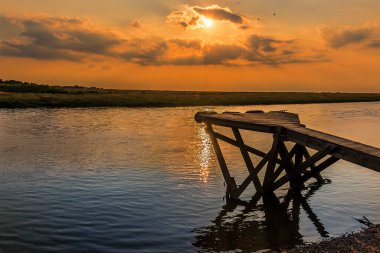 Blakeney, Norfolk, İngiltere 'de gün batımında Glaven Nehri' nin karşısında bir manzara.