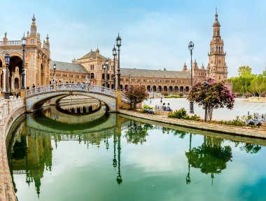 İspanya 'nın Sevilla kentindeki Plaza de Espana' nın güney kanalı boyunca yaz mevsiminin erken saatlerinde bir manzara.