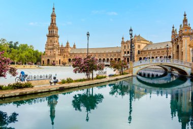 İspanya 'nın Sevilla kentindeki Plaza de Espana' daki kanalın durgun sularındaki yansımalar yaz sabahının erken saatlerinde