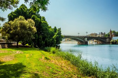 Guadalquivir nehrinin doğu kıyısı boyunca Seville, İspanya 'daki Triana Köprüsü' ne doğru bir manzara.