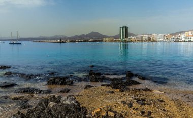 Güneşli bir öğleden sonra Lanzarote, Arrecife 'deki körfezin karşısındaki ana gezinti alanına doğru bir manzara.