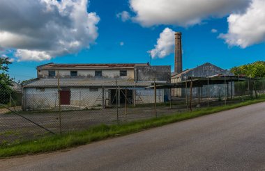 Bridgetown, Barbados dışında terk edilmiş şeker kamışı işleme fabrikasına doğru bir manzara.