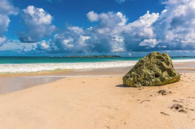 St. Martin 'de doğu sahilinin beyaz kumlarında yalnız bir kaya yığını.