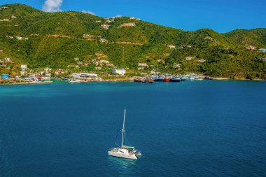 Bir katamaran zarif bir şekilde Tortola 'daki Road Town Marina' ya doğru yelken açıyor.