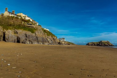 Kayalıkların güney sahili boyunca bir manzara ve güneşli bir günde Pembrokeshire, Tenby 'deki Saint Catherine Adası.