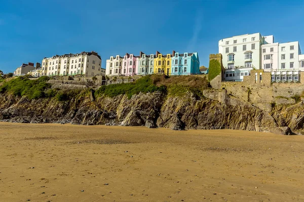 Güneşli bir günde Güney Sahili boyunca Tenby 'deki kayalıklara ve renkli otellere bakan Pembrokeshire,