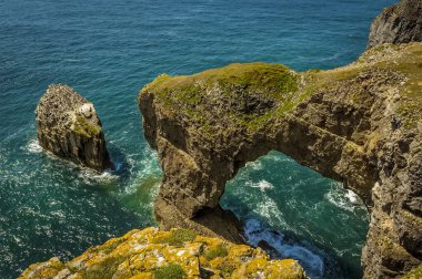 Galler 'in Yeşil Köprüsü ve yazın Galler' in Pembrokeshire sahilinde Razerbill martılarıyla dolu bir kaya yığını.