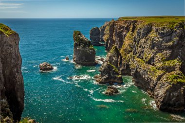 Kaya yığınları, yazın Galler 'in Pembrokeshire kıyısındaki gözlerden uzak bir koydan izleniyor.
