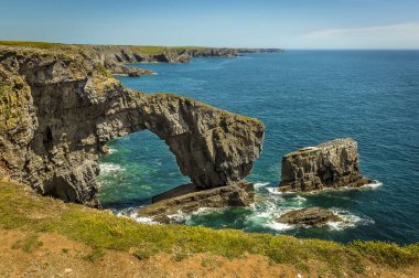 Doğal kemer, Galler 'in Yeşil Köprüsü olarak bilinir. Yazın başında Castlemartin yakınlarında, Pembrokeshire kıyısındaki yığınlarla birlikte.