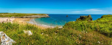 Yazın başında Galler 'in Pembrokeshire sahilinde Broad Haven plajı ve Church Rock' ın panoramik manzarası.