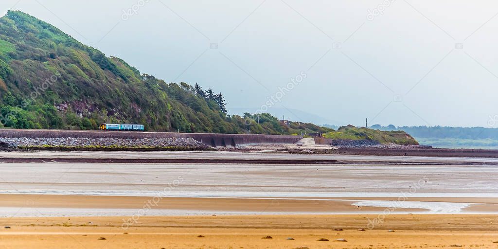 A view from the village of Llansteffan, Wales across the river Towy towards a train on the coastal route in summertime
