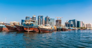 Dhow tekneleri ve modern gökdelenler baharda BAE 'deki Dubai Deresi' nde