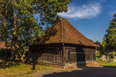 Yazın Suffolk UK, Doğu Bergholt 'taki kilisenin bahçesinde bir çan evi.
