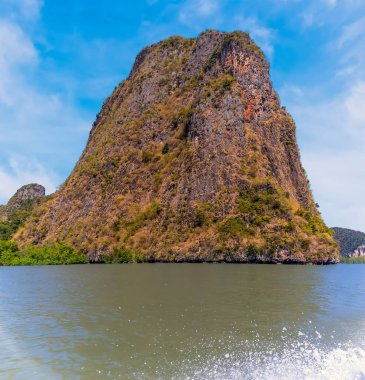 Tayland 'ın Phang Nga Körfezi' ndeki büyük renkli bir kireçtaşı adasının uzun kuyruklu sürat teknesinden bir görüntü.