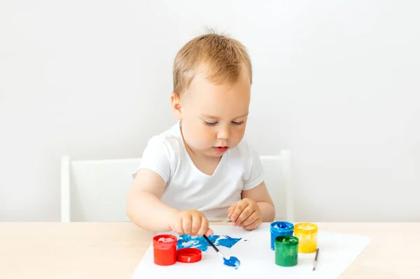 Criança Menino Anos Sentado Uma Mesa Fundo Isolado Branco Tintas — Fotografia de Stock