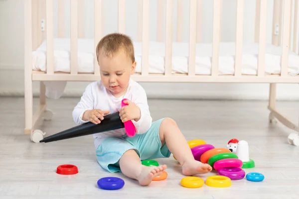小孩在婴儿床附近玩耍 小孩2岁 玩玩具 早期发育 — 图库照片