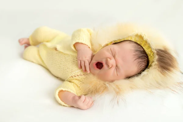 生まれたばかりの赤ちゃんは白い背景に 暖かいニットのスーツに テキストのためのスペースで甘くあくびをします — ストック写真