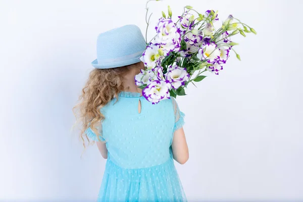 Parte Posterior Una Niña Vestido Azul Sombrero Con Brazo Flores —  Fotos de Stock