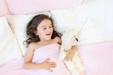 Sabah uyanan küçük kız yatakta.