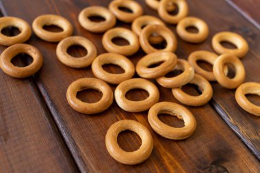 Kahverengi ahşap bir masada tahta bir tabakta simit. Kırsal tarzda. Ev yapımı kek. Metin için boşluk olan üst görünüm