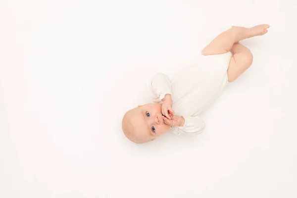 可愛いです赤ちゃん女の子でAホワイトボディスーツ上の白い隔離された背景を見てカメラ 赤ちゃん3ヶ月ベッドの上に横たわっ テキストのためのスペース — ストック写真