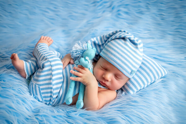 portrait of a newborn baby 0-14 days old on a blue fur background, a newborn's dream
