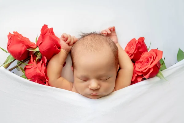 一个新生婴儿睡在一朵红玫瑰中的一张白色的床上 一个发短信的地方 一个健康的婴儿睡的地方 — 图库照片