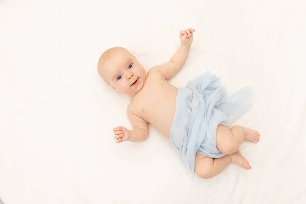 귀엽고 귀여운 아이가 배경에서 카메라를 개월된 아기가 침대에 문자가 있습니다 — 스톡 사진