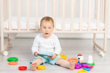 Küçük bir çocuk. 2 yaşında. Beşiğin yanında oynuyor.