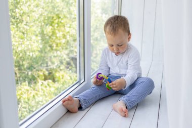 2 yaşında küçük bir çocuk pencerenin önünde anne ve babasını bekliyor.