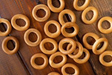 Kahverengi ahşap bir masada tahta bir tabakta simit. Kırsal tarzda. Ev yapımı kek. Metin için boşluk olan üst görünüm.