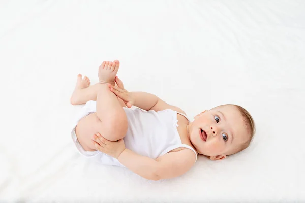 Miesięczna Dziewczynka Leżąca Łóżeczku Pokoju Dziecięcym Plecach Trzymająca Nogi Patrząca — Zdjęcie stockowe