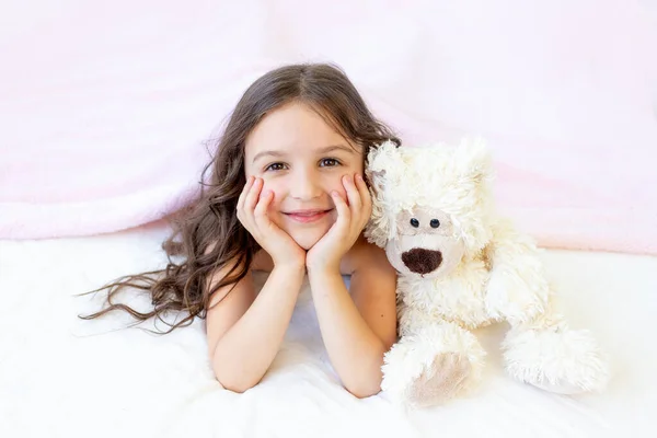 Egy Kis Mosolygós Lány Éves Fekszik Ágyban Egy Teddy Macival — Stock Fotó