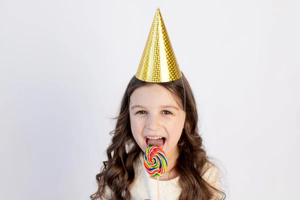 Una Niña Linda Está Comiendo Una Piruleta Grande Sombrero Festivo —  Fotos de Stock