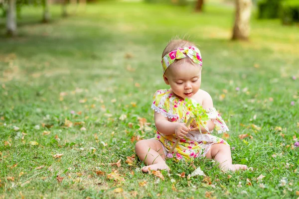 Маленька Дівчинка Місяців Сидить Зеленому Газоні Жовтій Сукні Грає Іграшкою — стокове фото